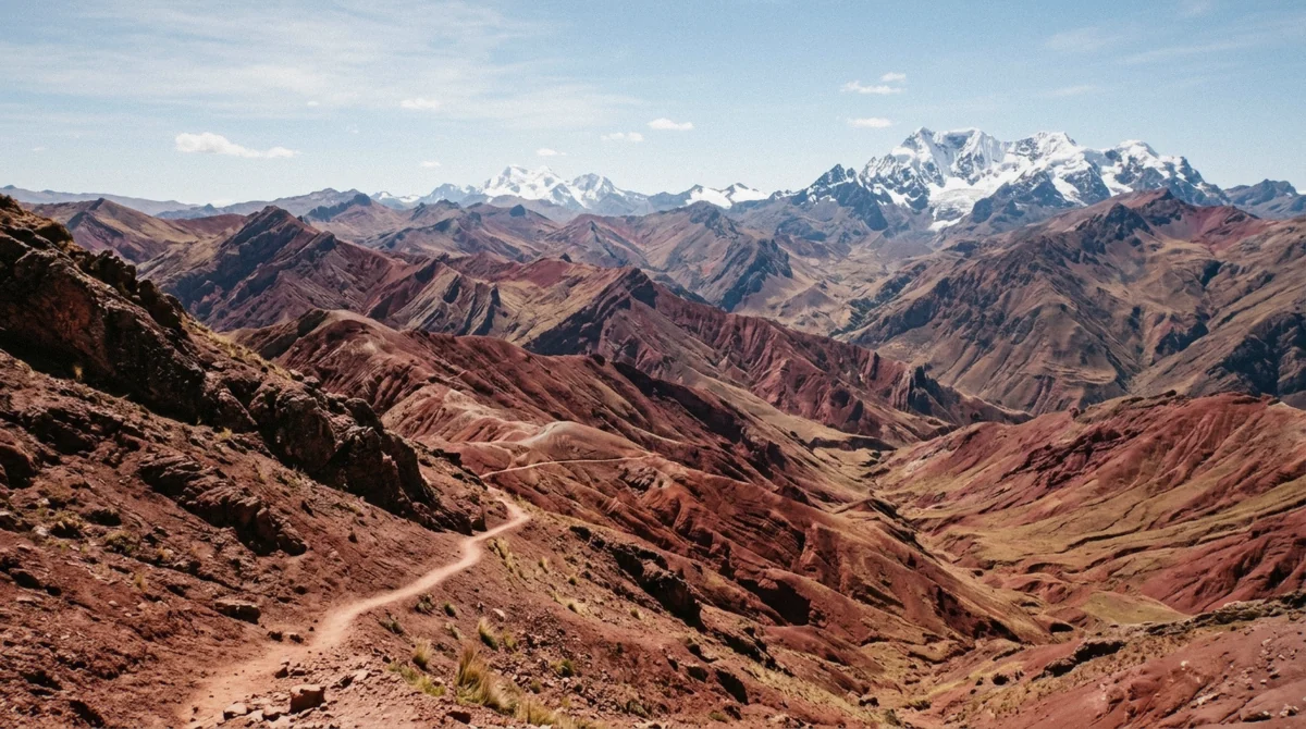 Wide view over the crimson ridges of the Red Valley at midday on a rainbow mountain and red valley tour in the Cusco region