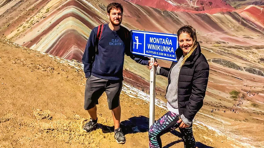 Hikers on the striped ridge of Vinicunca at sunrise on a rainbow mountain peru tour from Cusco