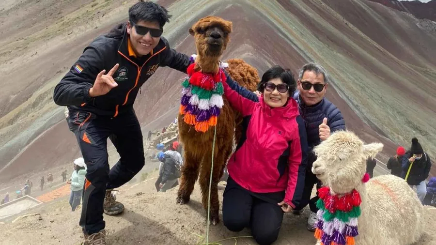 Group of trekkers climbing the final slope to the Vinicunca viewpoint on a rainbow mountain peru tour in the Cusco Andes